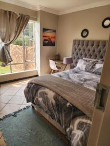 a bedroom with a large bed and a window at Mooikloof Mews with Solar Backup in Pretoria