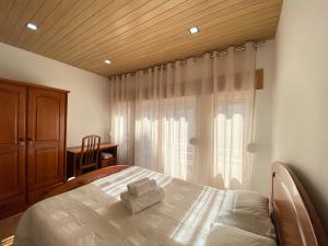 ein Schlafzimmer mit einem Bett und einem Fenster in der Unterkunft Casa Alto Do Viso in Figueira da Foz