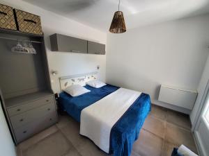 ein Schlafzimmer mit einem blauen und weißen Bett in einem Zimmer in der Unterkunft La casa Elisa Gîte T2 indépendant in Gréoux-les-Bains