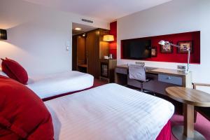 ein Hotelzimmer mit 2 Betten und einem Schreibtisch in der Unterkunft Crowne Plaza Montpellier Corum, an IHG Hotel in Montpellier