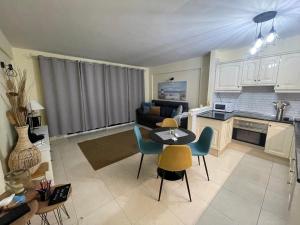 a kitchen and a living room with a table and chairs at Mona's Point Tenerife in San Miguel de Abona