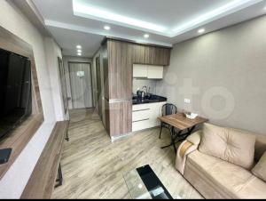 a living room with a couch and a kitchen at GOOD-VIBES Apartments in Batumi