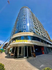 a tall building with a sign on the front of it at GOOD-VIBES Apartments in Batumi