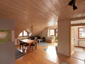 a living room with a wooden ceiling and a table at Ferienwohnung mit Dachterrasse in Achberg