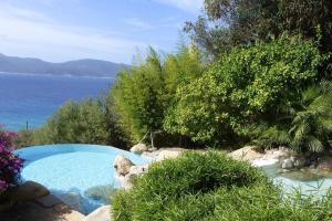 a swimming pool with a view of the water at Villas Valinco San Martinu Corse du Sud - vue et proche mer - piscines-7 chambres in Olmeto