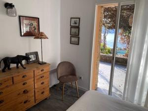 ein Schlafzimmer mit einem Hund auf einer Kommode und einem Fenster in der Unterkunft Villas Valinco San Martinu Corse du Sud - vue et proche mer - piscines-7 chambres in Olmeto