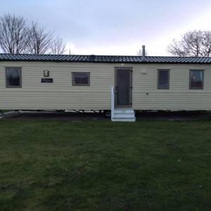 a white house with a door and a yard at 3 Bedroom at Seton Sands Caravan Hire in Edinburgh