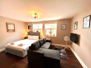 uma sala de estar com uma cama e um sofá em Lovely Studio close to Brighton Station em Brighton & Hove