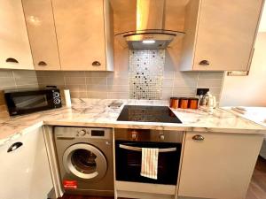 a kitchen with a stove and a washing machine at Lovely Studio close to Brighton Station in Brighton & Hove