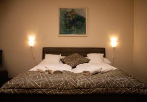 a bedroom with a bed with two lights on at Tavel boutique hotel in Prešov