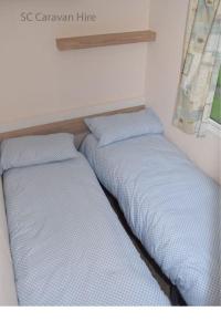 two beds sitting next to each other in a room at 3 Bedroom at Seton Sands Caravan Hire in Edinburgh