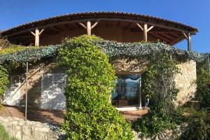 a building covered in ivy with a person standing outside at Villas Valinco San Martinu Corse du Sud - vue et proche mer - piscines-7 chambres in Olmeto
