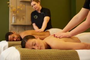 duas mulheres a receber uma massagem numa cama em Parkhotel Bad Arcen em Arcen
