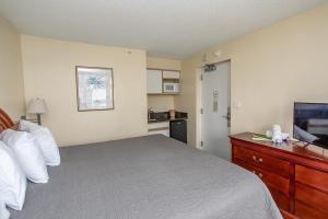 ein Hotelzimmer mit einem Bett und einem Flachbildfernseher in der Unterkunft Ocean View Studio King Suite Boardwalk Resort Unit 540 Sleeps 2 in Myrtle Beach + 28 Fotos