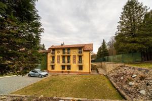 a yellow house with a car parked in front of it at Penzión Zunama in Bardejovské Kúpele