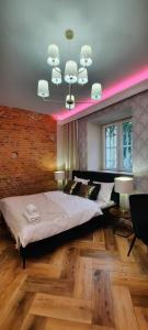 a bedroom with a large bed with a pink lighting at Apartament Tango in Krakow