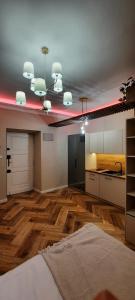 a large living room with a kitchen and wooden floors at Apartament Tango in Krakow