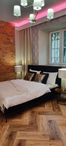 a bedroom with a large bed and a brick wall at Apartament Tango in Krakow