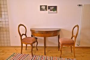uma mesa e duas cadeiras num quarto em Chasa Sassalba em Lü