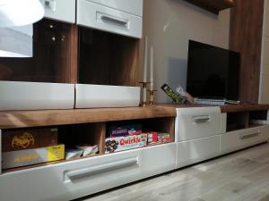 a living room with a white entertainment center with a television at Hanna apartman in Szeged