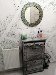 a bathroom with a dresser with a mirror and a radiator at Hanna apartman in Szeged