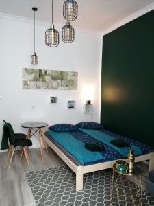 a bedroom with a large bed and a table at Hanna apartman in Szeged
