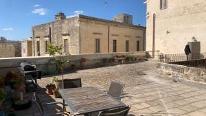 patio ze stołem i krzesłami w budynku w obiekcie La Dimora Del Barone w mieście Vernole