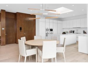 a kitchen and dining room with a wooden table and white chairs at Beverly Grove in Los Angeles