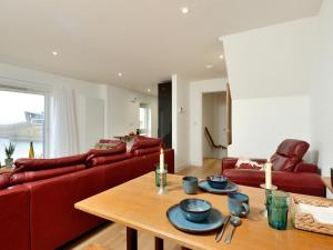 a living room with a red couch and a table at Generals Yard in Eyemouth