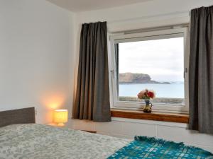 a bedroom with a window with a view of the ocean at Generals Yard in Eyemouth