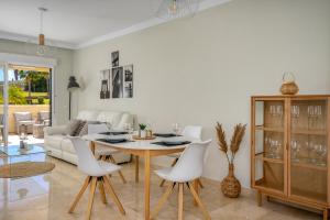 een woonkamer met een tafel en stoelen en een bank bij Bil bil golf apartment in Benalmádena