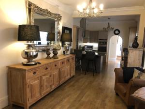The Vines Lodge luxury apartment في كْليثوربس: غرفة معيشة مع مرآة كبيرة على خزانة خشبية