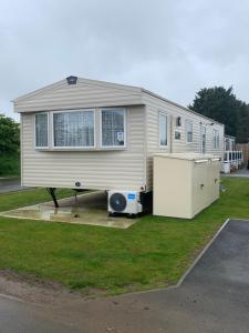 una casa móvil está estacionada en un patio en The Palm - Large Static Caravan near Margate, Kent, en Birchington