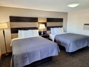 una habitación de hotel con 2 camas y una lámpara en Woodland Inn en Niagara Falls
