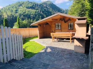 une cabane en bois avec une table de pique-nique et une clôture dans l'établissement Studio Eržen, à Zgornje Gorje