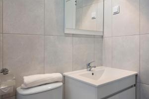 a white bathroom with a sink and a toilet at São Vicente House in São Vicente +15 photos