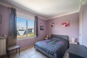 um quarto com uma cama, uma janela e uma secretária em Le Maréchal Juin - Appt 8 voyageurs em Perpignan