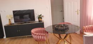 uma sala de estar com uma mesa e cadeiras e uma televisão em Dom pod Różą em Rząska