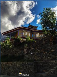 a house on top of a stone wall at Hikal Guest House in Hunza Valley