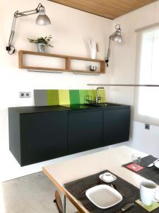 uma cozinha com um balcão preto e uma mesa em großzügiges Penthouse-Loft - modern möbliert mit Einbauküche in zentraler und ruhiger Lage em Bad Vilbel