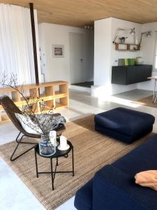 uma sala de estar com um sofá, uma cadeira e uma mesa em großzügiges Penthouse-Loft - modern möbliert mit Einbauküche in zentraler und ruhiger Lage em Bad Vilbel