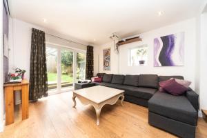 uma sala de estar com um sofá e uma mesa em 6 bedrooms beautiful home 3 bathrooms, quiet location with garden near Legoland Windsor Heathrow em Maidenhead