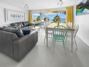 sala de estar con sofá, mesa y sillas en Puerto Velero Primera Línea Primer Piso al lado de la Playa! 5 pax, en Puerto Velero