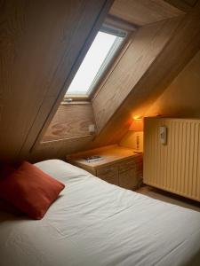 Oosterzele的住宿－De Keukentafel B&B，阁楼卧室配有带窗户的床
