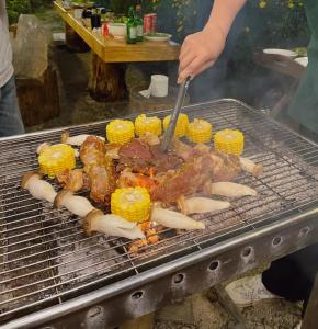 a person is cooking food on a grill at Nguyên căn - Góc sân và Khoảng trời Dalat Homestay in Ấp Phước Thánh