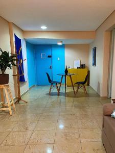 a living room with a blue door and a table and chairs at Studio Aurora - Recife in Recife
