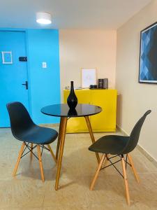 勒西菲的住宿－Studio Aurora - Recife，一张桌子,上面有两把椅子和一个花瓶