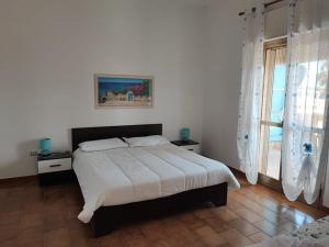 a bedroom with a bed and a large window at Casa Limone in San Pietro in Bevagna