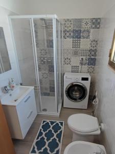 een badkamer met een douche, een toilet en een wasmachine bij Casa Limone in San Pietro in Bevagna