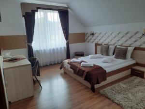 ein Schlafzimmer mit einem großen Bett und einem großen Fenster in der Unterkunft Villa Prestige in Sovata
